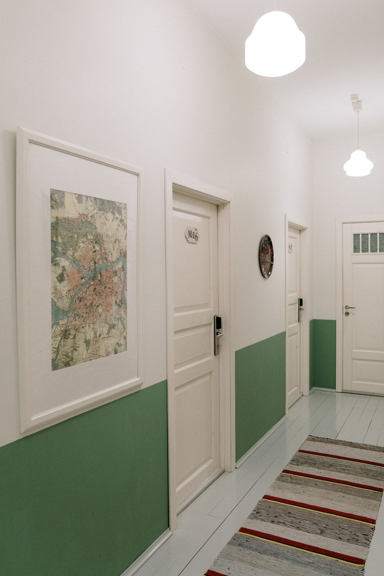 A sleek and minimalist hallway with paintings and modern lighting, perfect for interior design inspiration.